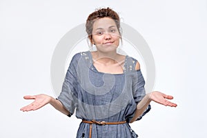 Shrugging ethnic woman in doubt doing shrug showing open palms