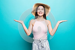 Shrugging woman in doubt doing shrug showing open palms, gesturing, look to side on blue background