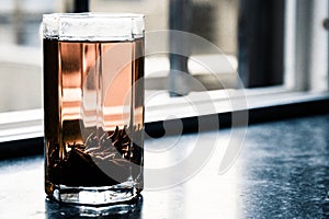 Shu puerh tea brewed in glass cup on window sill