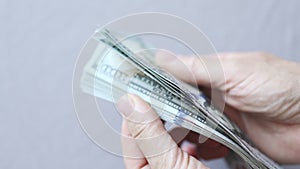 shuffling stack pack of hundred 100 dollar bills on light grey background