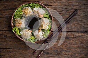 Shumai shrimp with sauce, Steamed shrimp dumplings dim or dim sum and vegetable on wooden table, Cantonese Dimsum food cuisine for