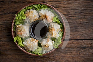 Shumai shrimp with sauce, Steamed shrimp dumplings dim or dim sum and vegetable on wooden table, Cantonese Dimsum food cuisine for