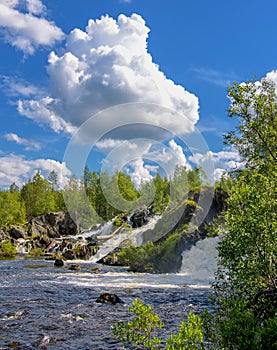 Shuonijoki Falls. Motion Blur Waterfalls Nature Landscape in Nikel, Murmansk region, Russia. Lush green trees, rocks and flowing photo