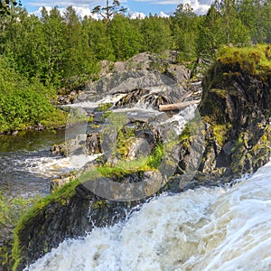 Shuonijoki Falls. Motion Blur Waterfalls Nature Landscape in Nikel, Murmansk region, Russia. Lush green trees, rocks and flowing photo