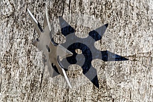 Shuriken (throwing star), traditional japanese ninja cold weapon stuck in wooden background