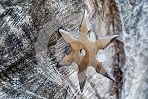 Shuriken (throwing star), traditional japanese ninja cold weapon stuck in wooden background