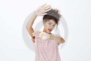 Shut camera off. Portrait of displeased unhappy female student in striped t-shirt, pulling hands towards camera