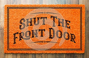 Shut the Front Door Orange Welcome Mat On Wood Floor Background