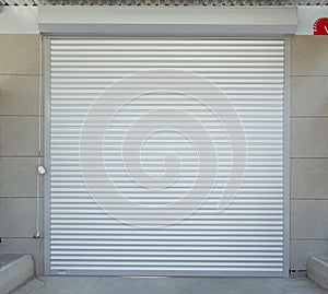 Shutter door or roller door and concrete floor outside .White Automatic shutters in a house . gates in the garage . Automatic