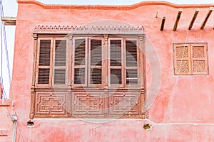 Shuttered window on a pink stucco building in Faiyum