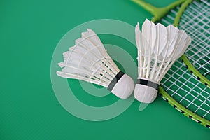 Shuttlecock and rackets. Badminton sport equipments on green background.