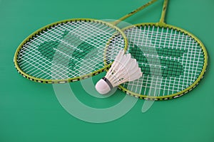 Shuttlecock and rackets. Badminton sport equipments on green background