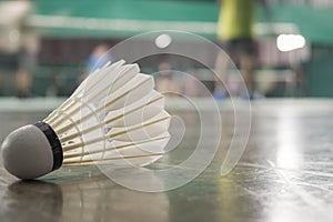Shuttlecock resting on a badminton racket with badminton player are competiting