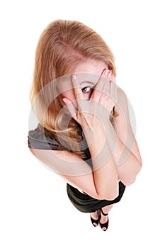 Shy afraid woman peeking through fingers isolated.