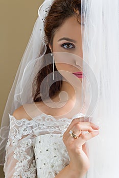 Shy bride behind curtains