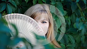Shy girl with a wooden fan