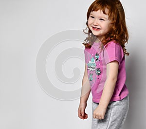 Shy smiling cutie smiling little toddler girl in sportswear studio shot