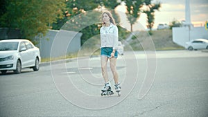 A shy teenage girl in rollerblades skating on the road