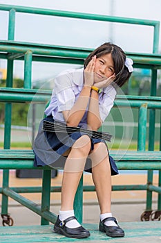 Shy Thai schoolgirl sitting on a stand