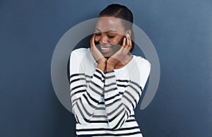 Shy, thinking and black woman with a smile, ideas and model on a grey studio background. African person, mockup space