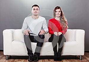 Shy woman and man sitting on sofa. First date.