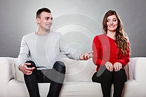 Shy woman and man sitting on sofa. First date.