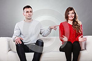 Shy woman and man sitting on sofa. First date.