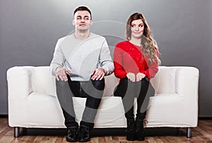 Shy woman and man sitting on sofa. First date.