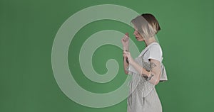 Shy woman reversing her dance step over green screen