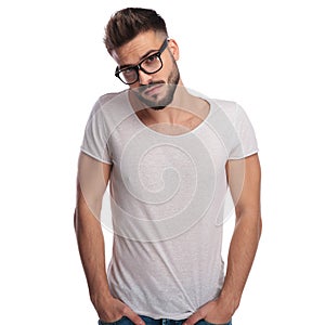 Shy young casual man wearing glasses