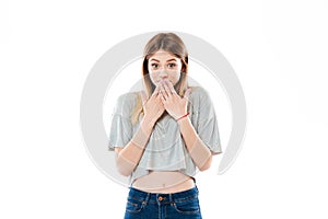 Shy young girl standing and covering her mouth with hands