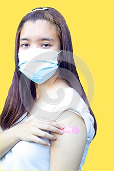 Sian teenager showing arm with adhesive plaster bandage after getting vaccinated for coronavirus