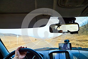 Siberia Baikal, Russia - November 20, 2020: View from of car interior from side of driver to the road and autumn yellow