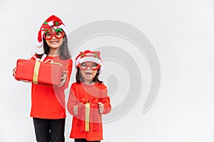 Sibling Asian girls in red Santa hat with gift boxes on white background