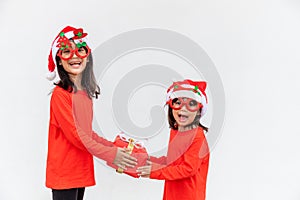 Sibling Asian girls in red Santa hat with gift boxes on white background