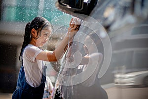 Sibling Asian girls wash their cars and have fun playing indoors on a hot summer day