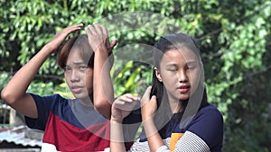 A Sibling Asian Teens Combing Hair
