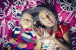 Sibling children playing having fun on bed