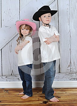 Sibling cowboy and cowgirl in sweet pose