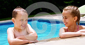 Sibling enjoying in swimming pool