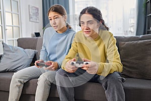 Sibling playing game console at home