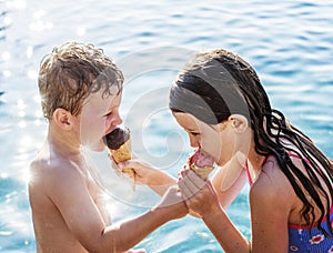 Sibling sharing ice cream by the pool