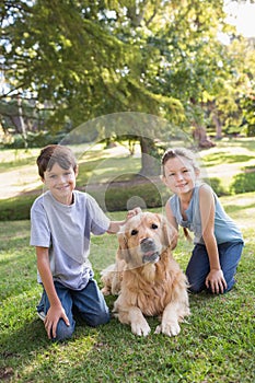 Sibling with their dog in the park