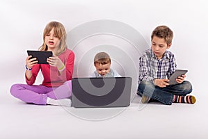 Sibling using tablets and laptop