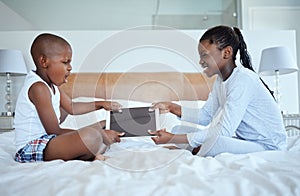 Sibling wars. two siblings fighting in a game of tug of war over their digital tablet.