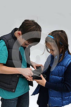 Siblings analysing an old photo camera