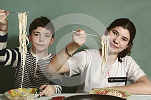 Siblings boy and girl with spaghetti