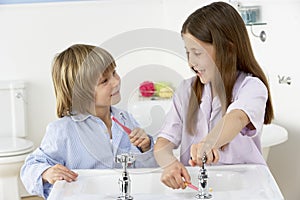 Siblings Brushing Teeth Together at Sink