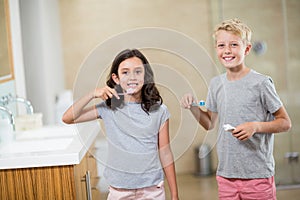 Siblings brushing their teeth in bathroom