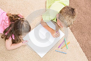 Siblings colouring on the rug